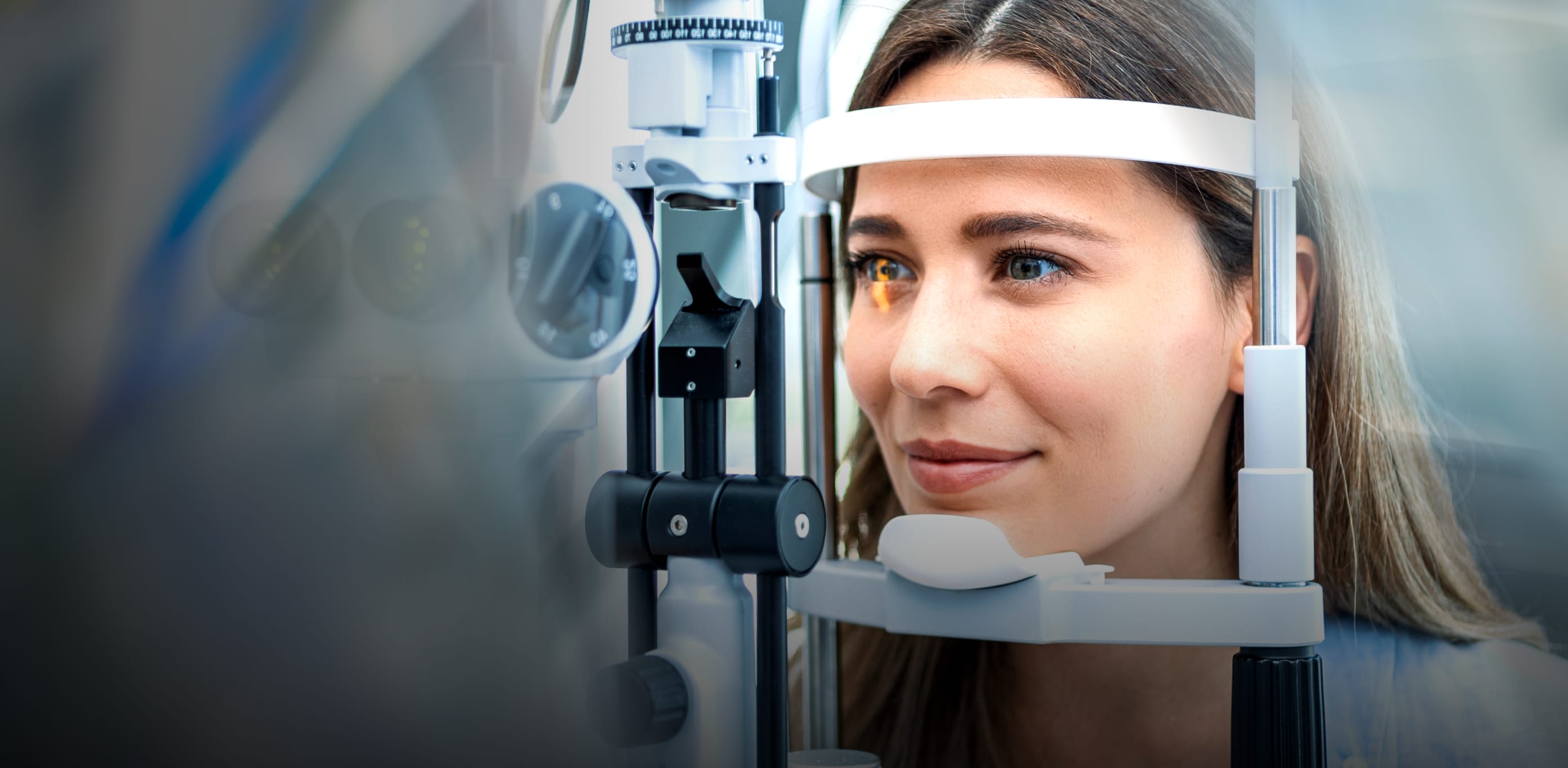 A woman looking into an eye testing machine
