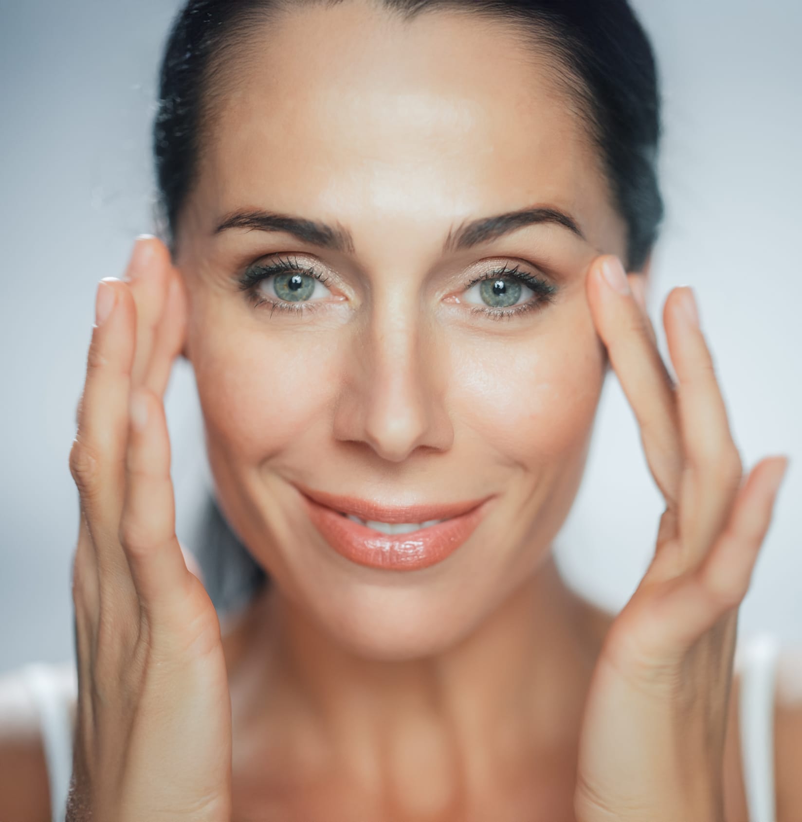 Woman smiling touching eyes